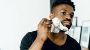 laser for pseudofolliculitis barbae as depicted by a black man shaving